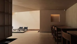 A minimalist restaurant interior with wooden tables and chairs