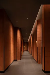 A modern, tiled corridor with warm lighting and minimalist design.