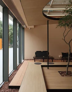 Modern interior design featuring wooden benches and rock landscaping within a cafe setting.