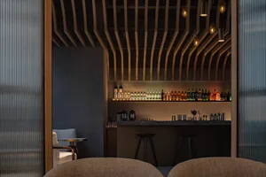 An industrial bar with metallic shelving and a variety of bottles on display.