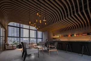 A modern coffee shop bar with wooden elements and concrete flooring, featuring sleek furniture and a well-stocked bar.