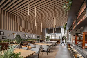 A modern industrial restaurant interior with wooden tables, concrete walls, and metal accents.