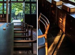 A modern restaurant interior with a long dining table and chairs, featuring wooden materials and a sense of tranquility.