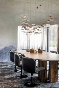 Modern dining room featuring concrete tabletop, wooden legs, and metal chairs with black bases.