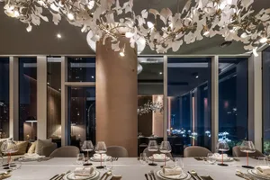 A modern restaurant interior featuring elegant lighting fixtures designed with glass and metal elements, complemented by fabr
