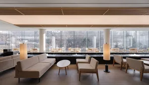 Modern interior design of a restaurant featuring glass walls and concrete flooring.