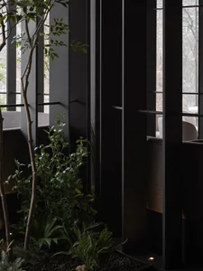 Modern, industrial-style restaurant interior with metal walls and green plants.