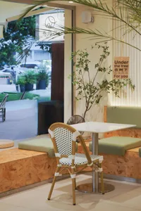 A cozy cafe interior featuring wooden seating and white plaster walls.