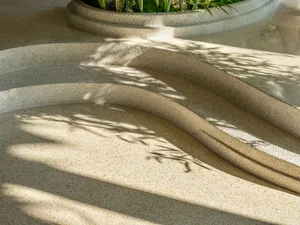 Curved concrete steps with shadow patterns created by plants