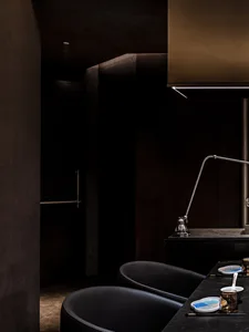 A modern restaurant interior with black furniture, metallic accents, and a sleek design.