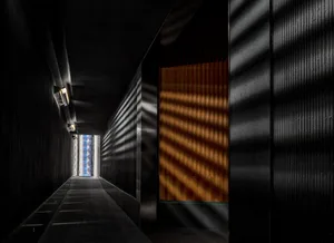 A minimalist corridor featuring wooden paneling and a long, narrow window letting in natural light.