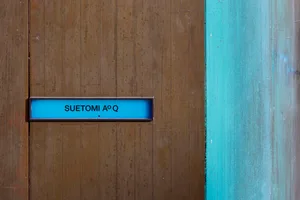 Blue signage mounted on a wooden door with minimalist design.