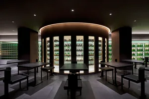 Modern minimalist restaurant interior featuring black tables and a sleek, minimalist design with steel and glass materials.