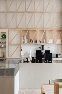 Modern kitchen with transparent wood shelves and sleek white cabinetry.