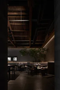 Modern restaurant interior with concrete walls and wooden beams and fixtures