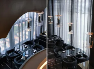 A modern restaurant interior featuring metallic lighting fixtures and glass elements.