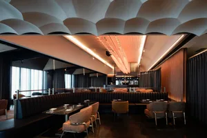 Modern restaurant interior with textured concrete and metal finishes