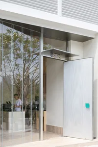 A modern storefront with glass walls and concrete elements.