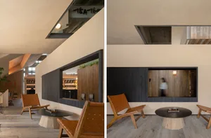 Modern indoor space with concrete walls, wooden seating, and a circular table.