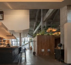 工業風餐廳室內，展現木質、混凝土與金屬材質。