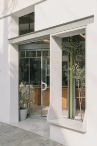 A minimalist storefront with large glass doors and a marble window sill, showcasing a modern retail space.