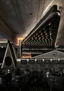 Modern bar with sleek, black furniture and concrete walls