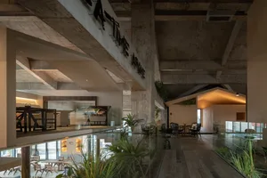 A modern cafe interior featuring exposed concrete ceiling beams and timber flooring.