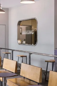 Modern industrial-style cafe interior with wooden tables and metal stools