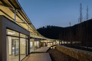 Modern residential building with wooden materials and large glass windows.
