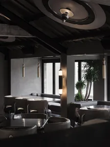 Industrial-style restaurant interior with metal, glass, and concrete materials.