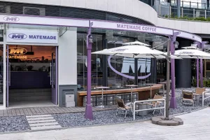 Modern coffee shop exterior with concrete and glass materials.