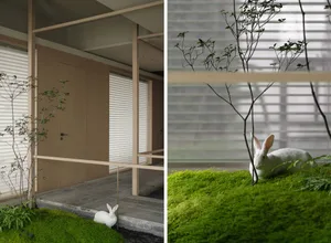 A modern minimalist interior space with wooden elements and a white rabbit on a green moss-covered ground.