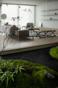 A modern minimalist living room with a white sofa, wooden coffee table, and a glass partition