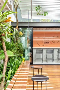 Modern cafe interior with mixed materials and greenery.