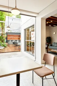 A contemporary coffee shop featuring concrete and glass materials and a minimalist design.