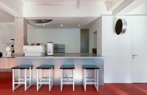 Modern minimalist coffee bar featuring a concrete countertop and stools.