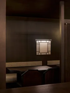 Dark wooden restaurant booth with a lit window panel