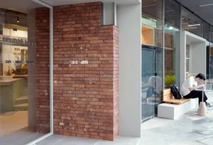 A modern cafe exterior featuring a red brick wall.