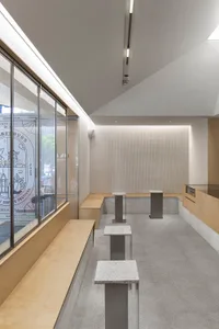 A modern coffee shop interior with concrete and marble surfaces.