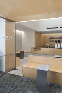 A minimalist coffee shop interior with wooden elements and a sleek counter.