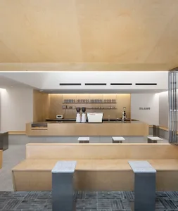 Modern minimalist coffee shop interior with wood, concrete, and metal elements.