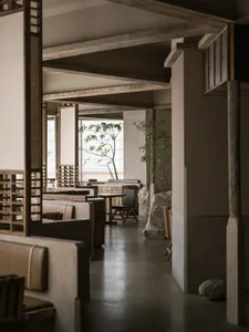 Modern restaurant interior with concrete and wood materials.