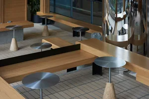 Modern industrial-style coffee shop interior with wood furniture, metal accents, and concrete elements.