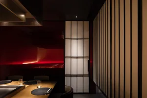 Modern restaurant interior featuring textured glass paneling walls and red lighting