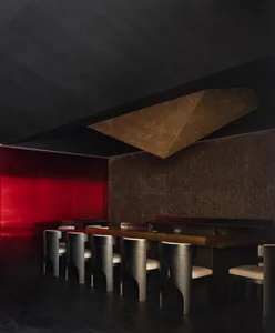 Minimalist restaurant interior featuring a metallic counter and sleek seating.