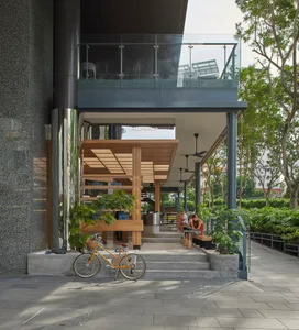Outdoor cafe with concrete floor, wooden seating, and glass walls.