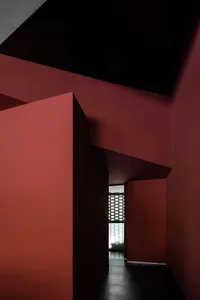 A hallway with red walls and black ceiling.