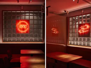 A modern restaurant interior with red neon signs and glass-block walls.
