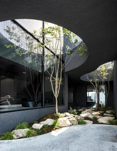 Minimalist interior design with glass, concrete, and stone materials.