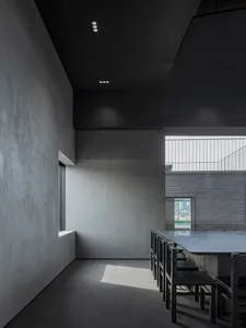 A minimalist restaurant interior with industrial materials and large windows.